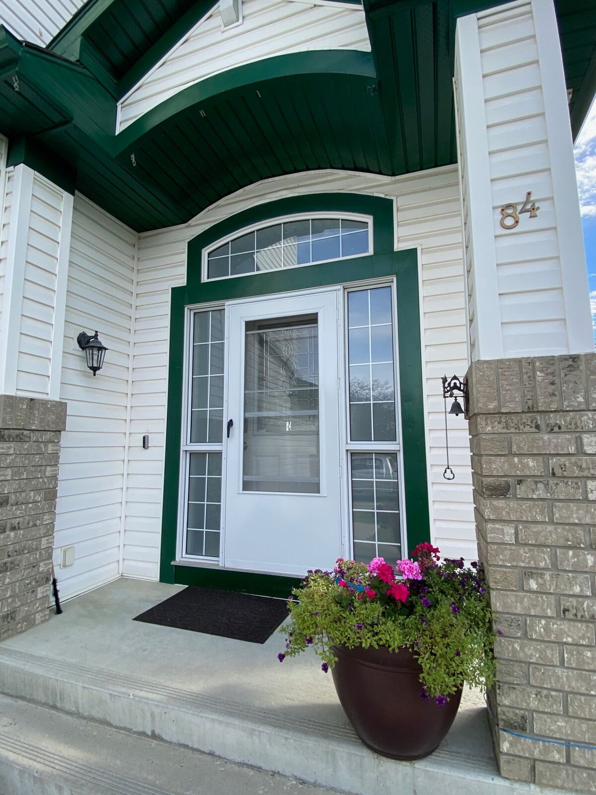 White entry door with arched transom and green trim