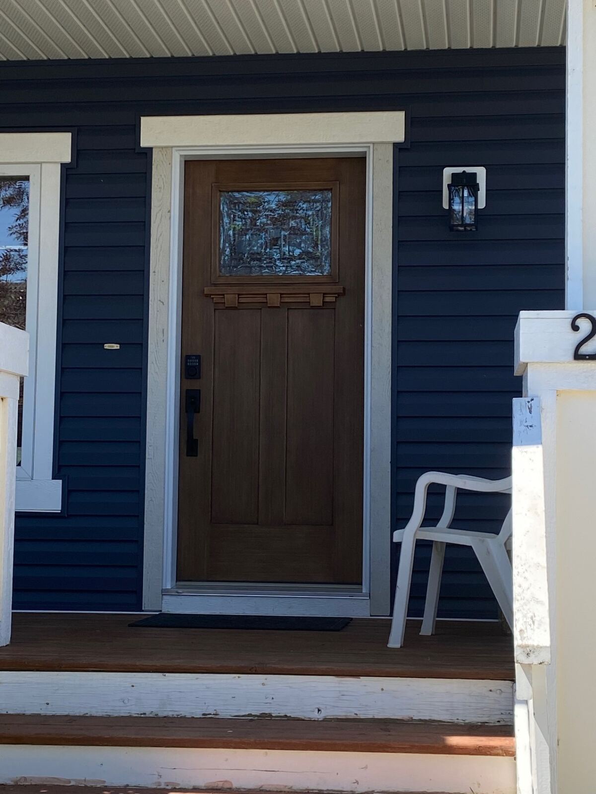 Craftsman wood-look door on a navy lap-sided home