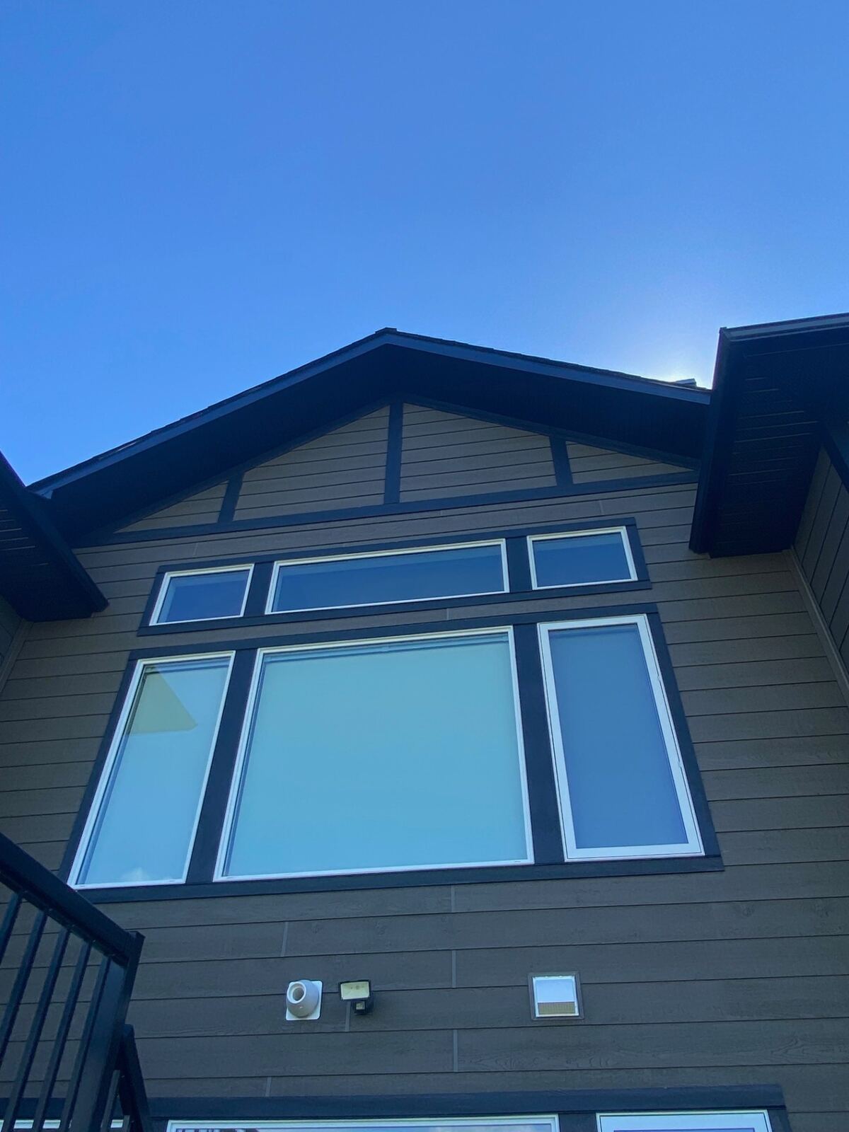 Craftsman home with brown siding and dark trim windows