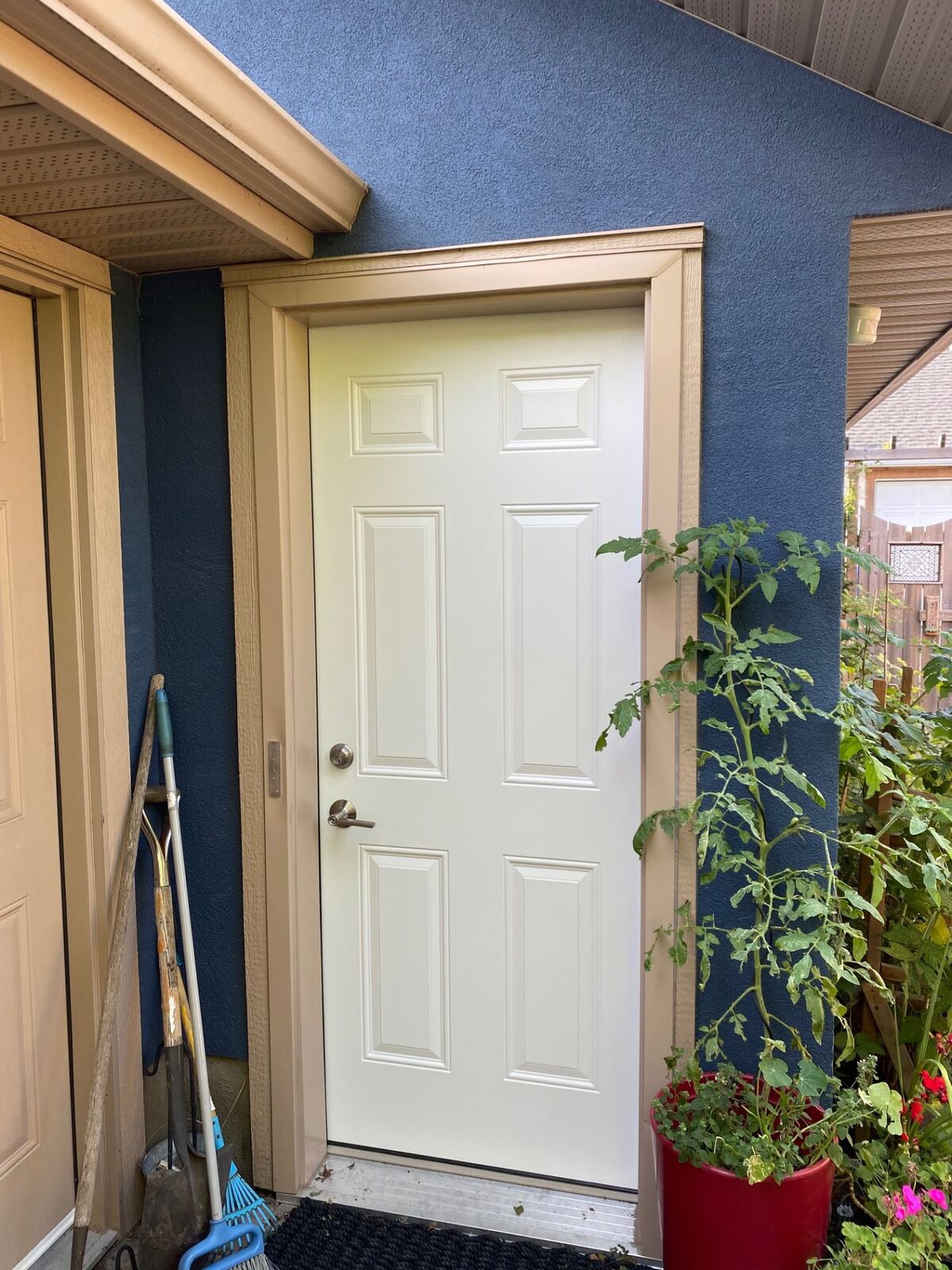 White six-panel side entry door against blue stucco